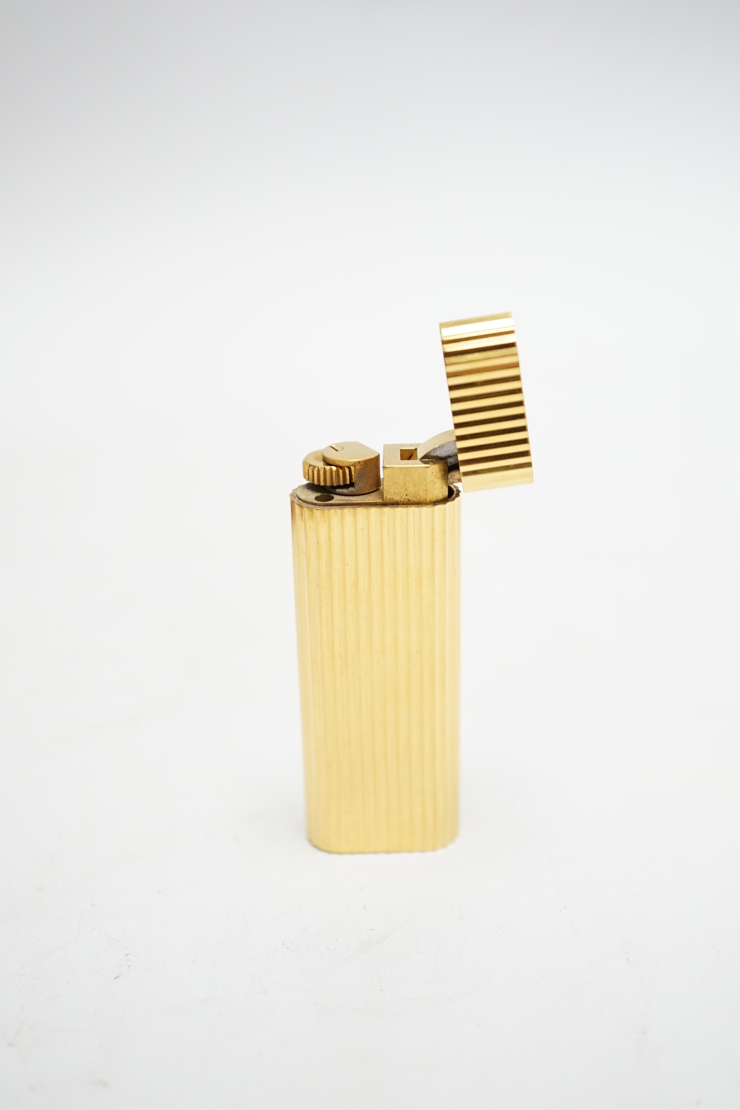 A Cartier gold plated lighter, with box and certificate.